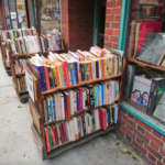 A cart full of books stationed outside a storefront