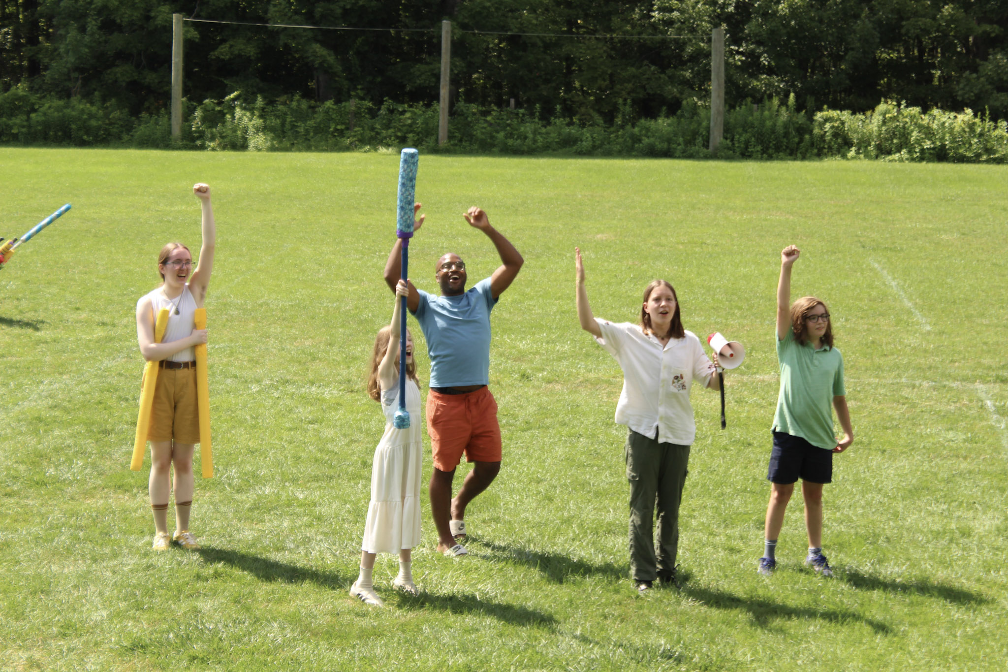 People raising their weapons in a LARP competition