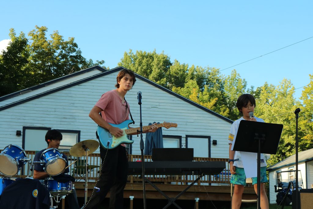 Three boys playing a song on a concert set