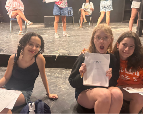 Child actors on stage reading scripts