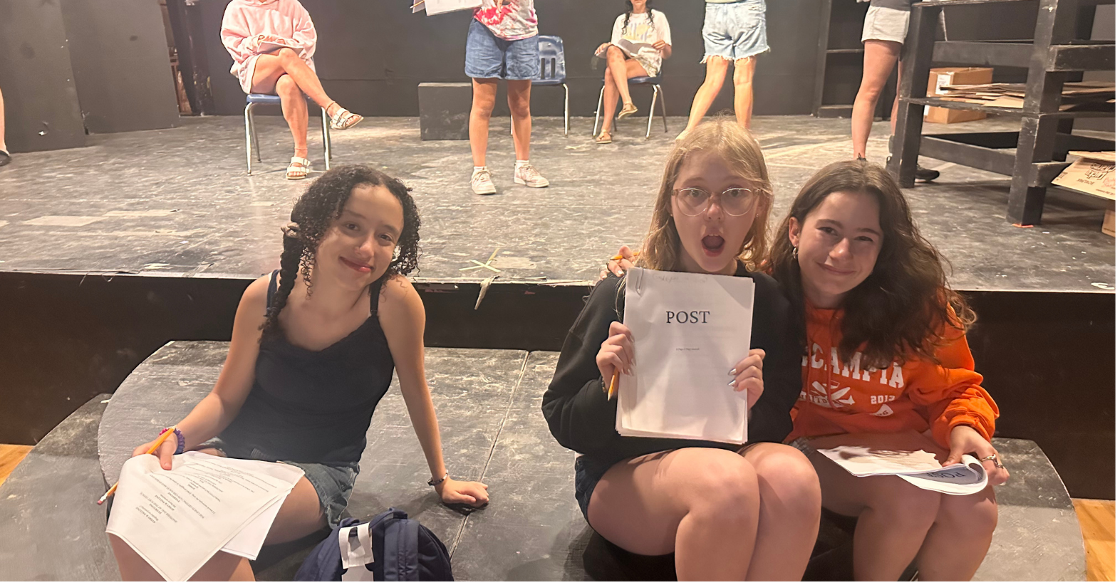 Child actors on stage reading scripts